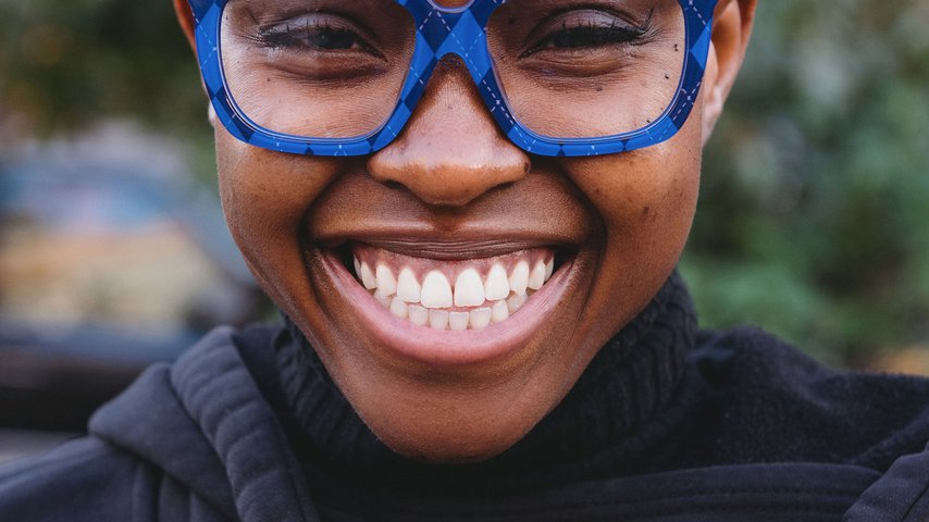 Smiling Black woman wearing Vontelle frames