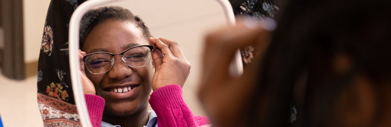 Child trying on glasses in a mirror