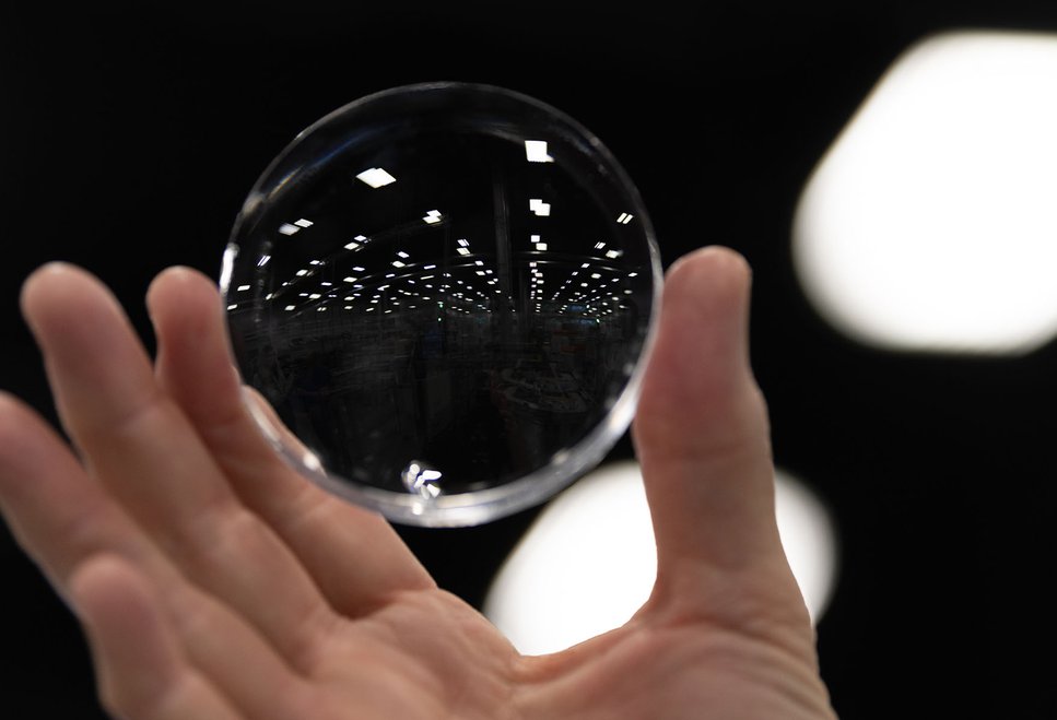 Hand holding up glasses lens to light