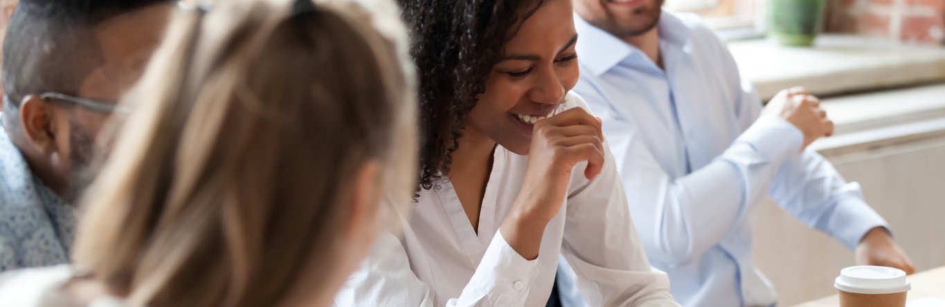 Group of young professionals talking at a conference table.