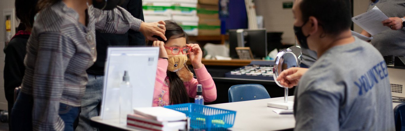 young girl trying on glasses