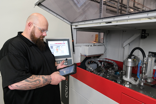 Man holding tablet inspecting a machine