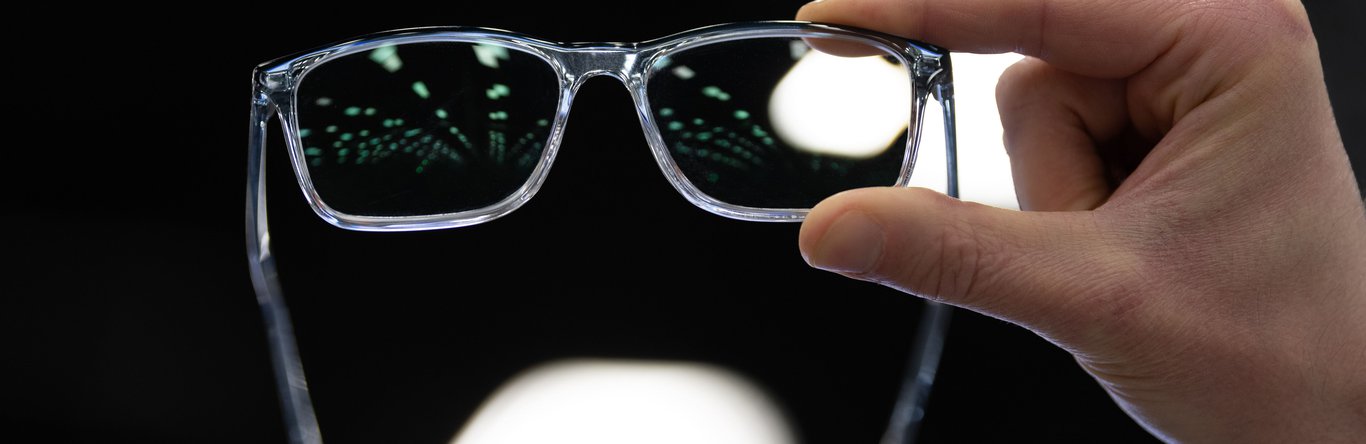 Hand holding up glasses to a light