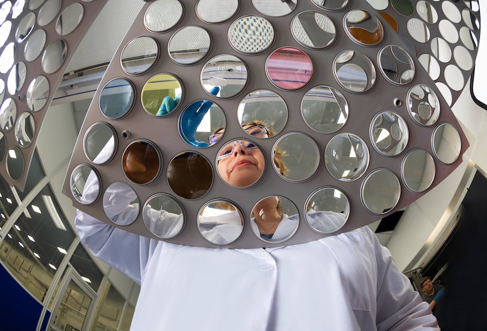 woman looking over sheet of lenses