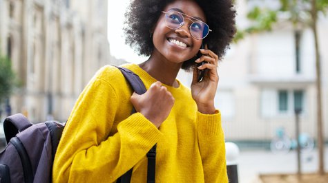 Smiling African American woman with glasses talking on the phone.