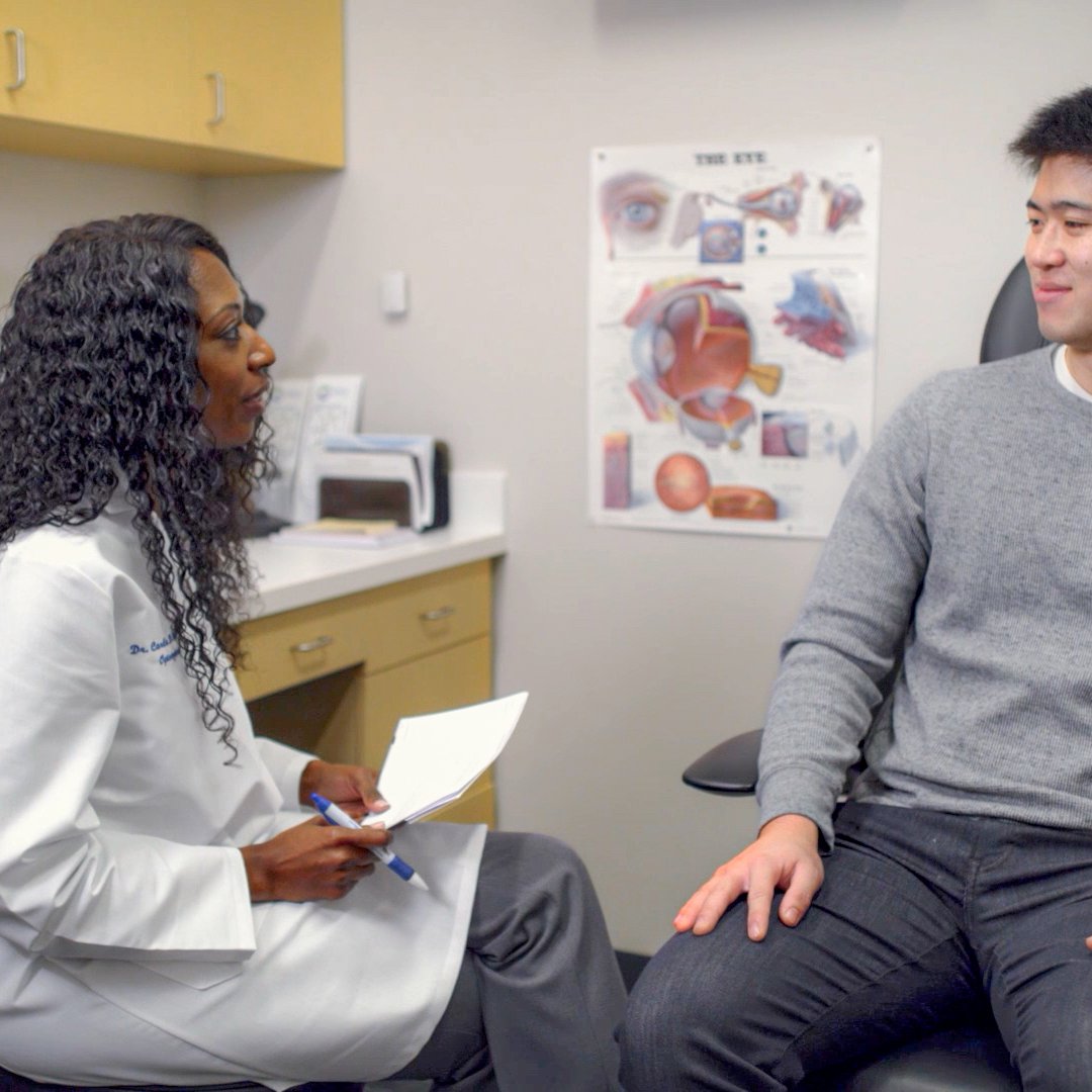 Young woman doctor talking to patient in exam room.