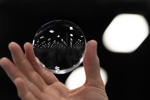 hand holding a clear glasses lense