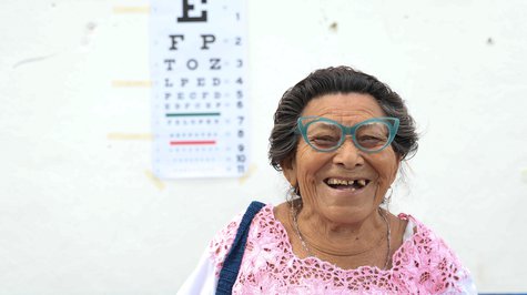 older woman laughing while wearing glasses